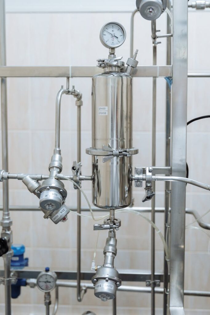 pexels-photo-8940464 Close-up of a stainless steel industrial plumbing system with pressure gauges and steel pipes.